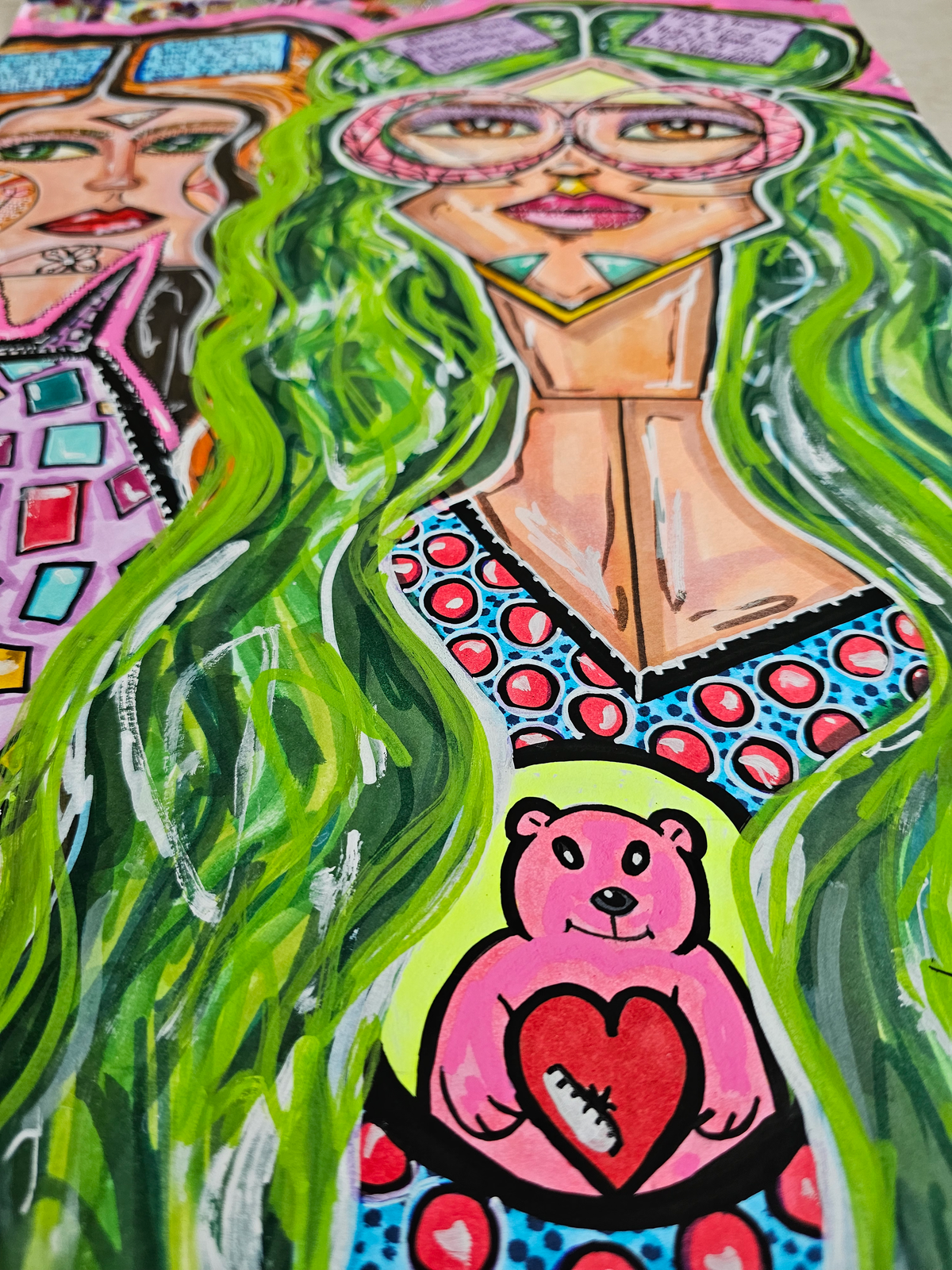 Selena & Helena detail: a pink teddy bear holding a red heart below falling green hair