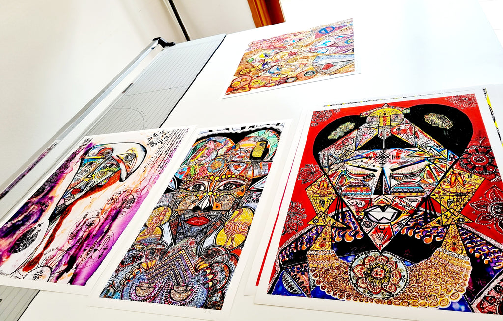 A group of Shabsoug Art fine art prints laid out on a studio table, showing the paper, white borders and colour
