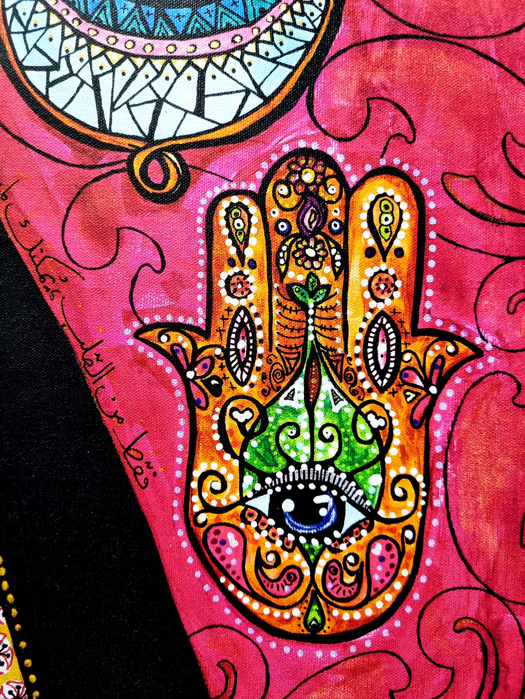 Qadira limited edition print detail: a gold and orange hamsa with a green heart and blue eye, the artist's signature at the left