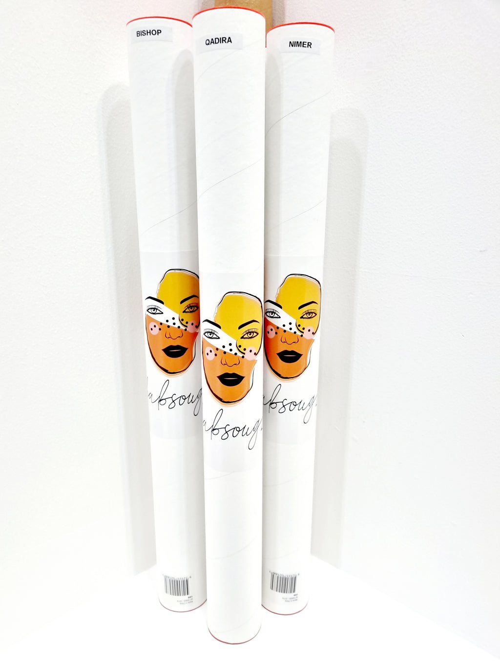 Three white postal tubes with the studio's yellow face sticker, used to ship the prints