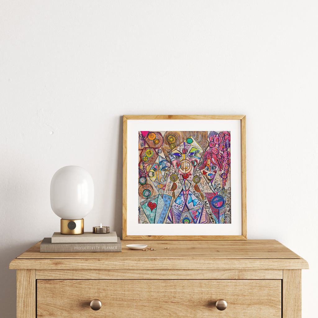 Trinity print framed in oak on a timber chest of drawers, beside a rounded white table lamp