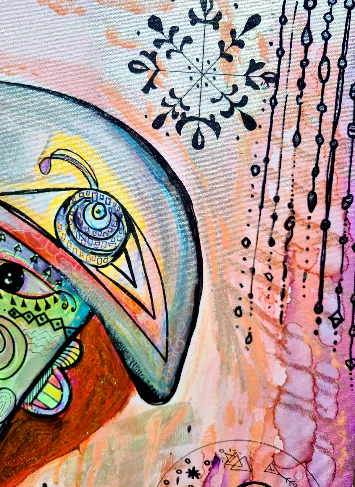 Rosado detail: a blue eye under a yellow lid, with inked snowflakes and hanging bead lines