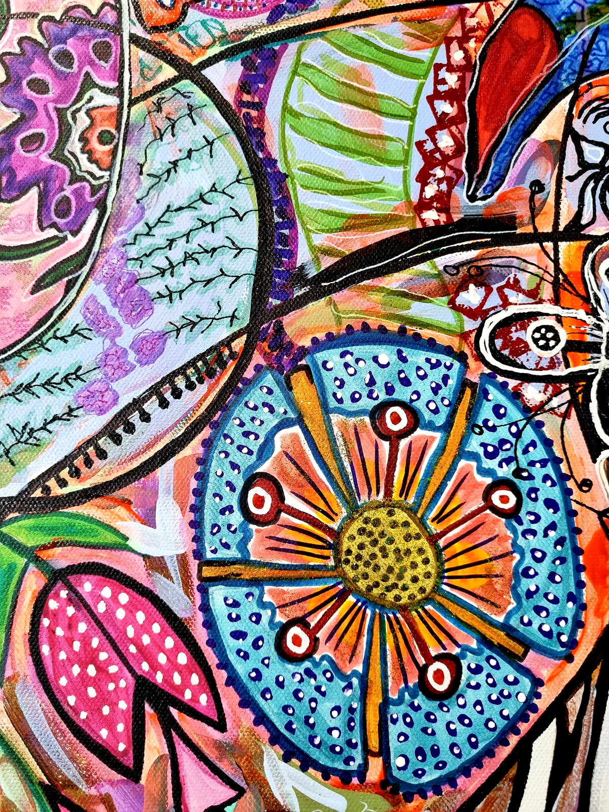 Wiana detail: a blue and orange flower wheel with a gold centre beside a spotted pink petal