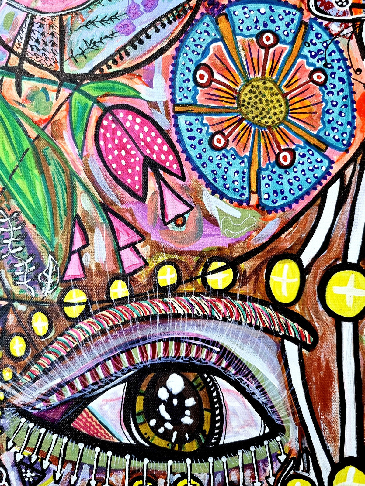 Wiana print detail: a heavily lashed eye below a blue and orange flower wheel and yellow beads
