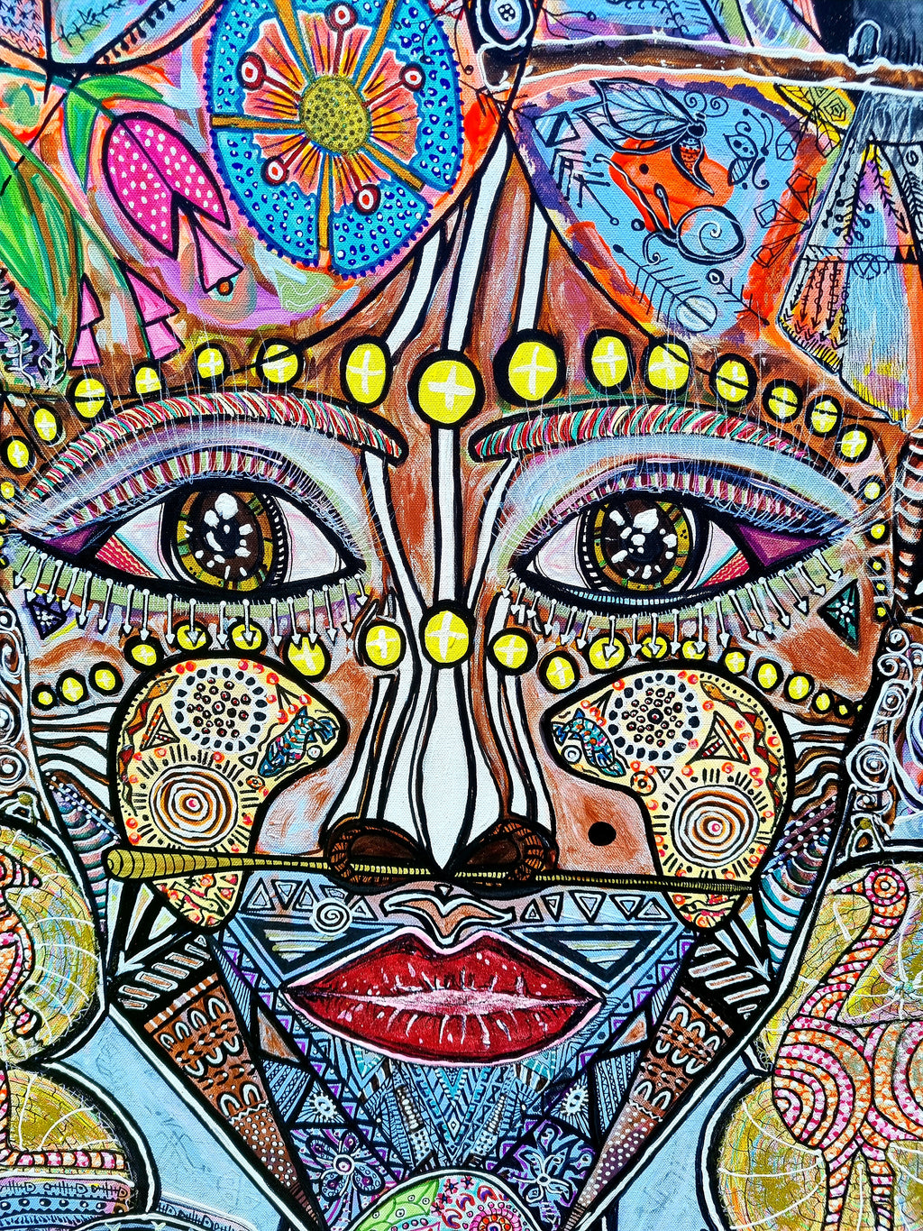 Wiana detail: the figure's face, almond eyes, a dotted brow line and deep red lips