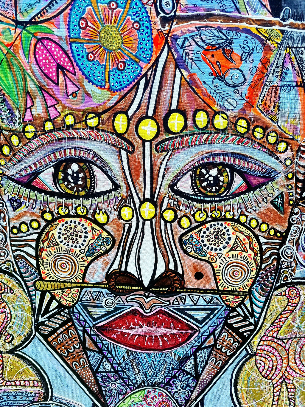 Wiana print detail: two dark eyes under rows of yellow beads, with a red mouth below