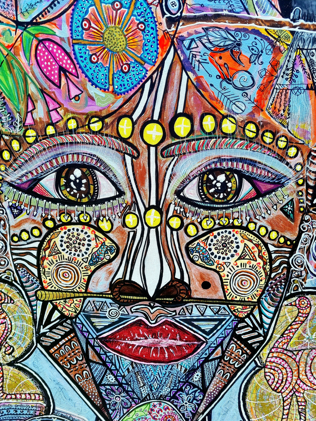 Wiana print detail: two dark eyes under rows of yellow beads, with a red mouth below