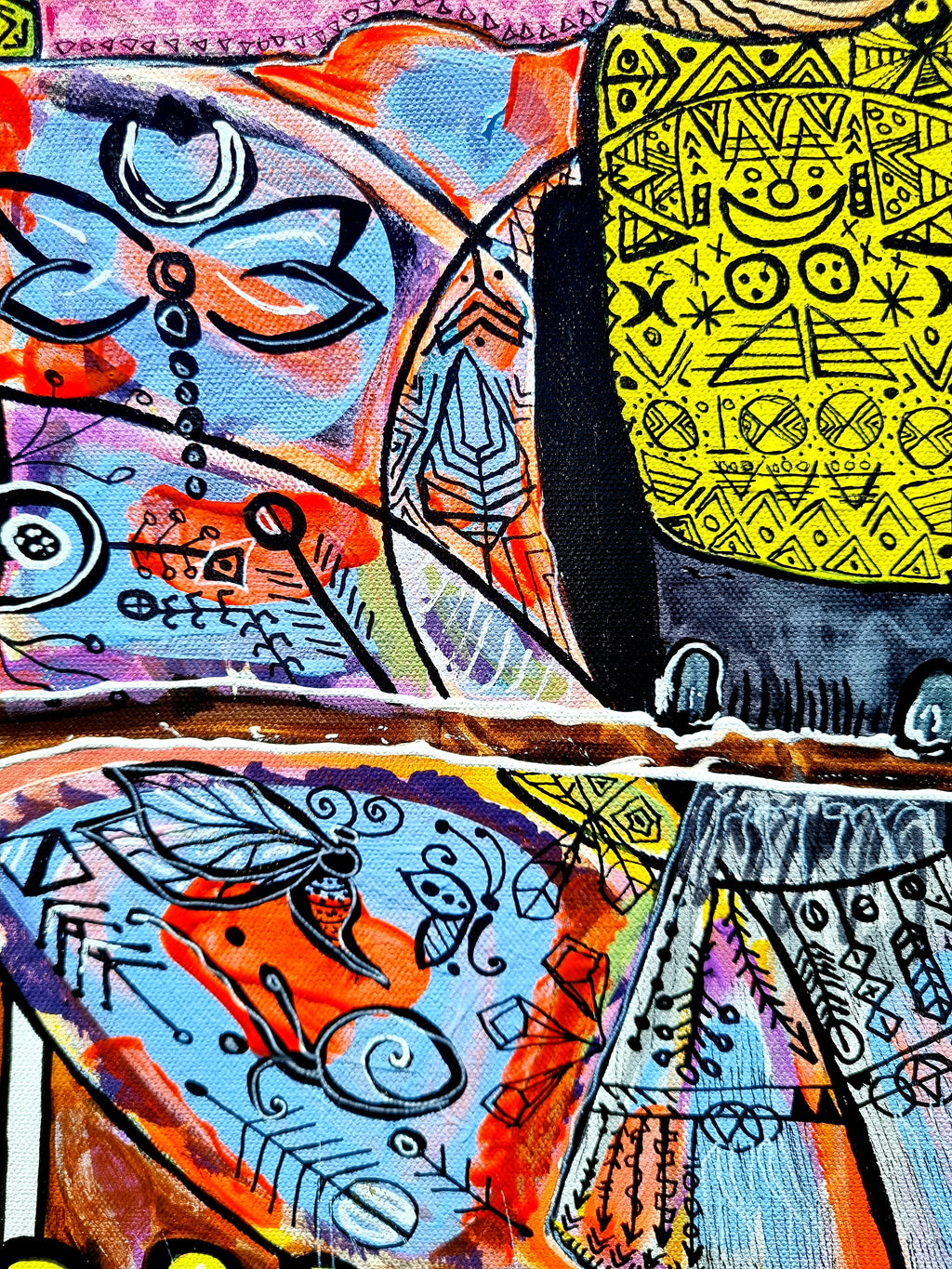 Wiana detail: a bright yellow panel of hand drawn symbols with dragonflies floating around it