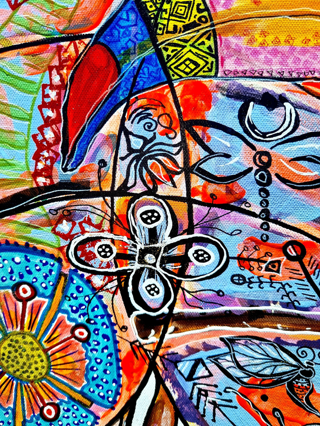 Wiana print detail: a scarlet and blue leaf shape above an orange sunflower wheel on teal