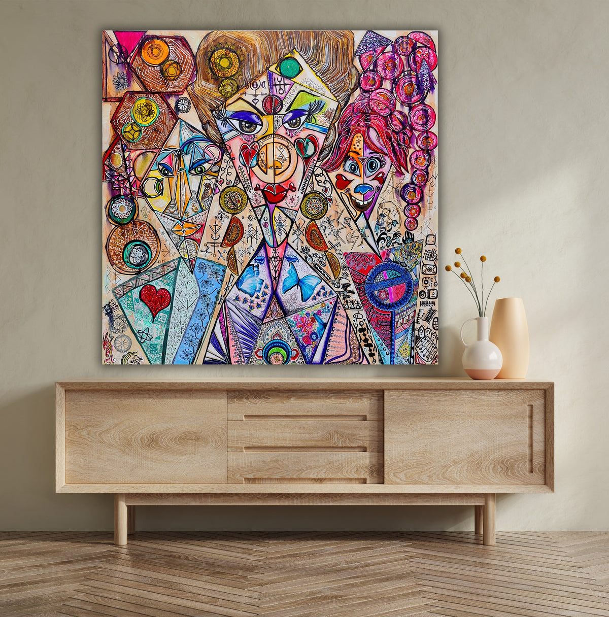 Trinity hung above a timber sideboard, showing the scale of the square canvas in a room