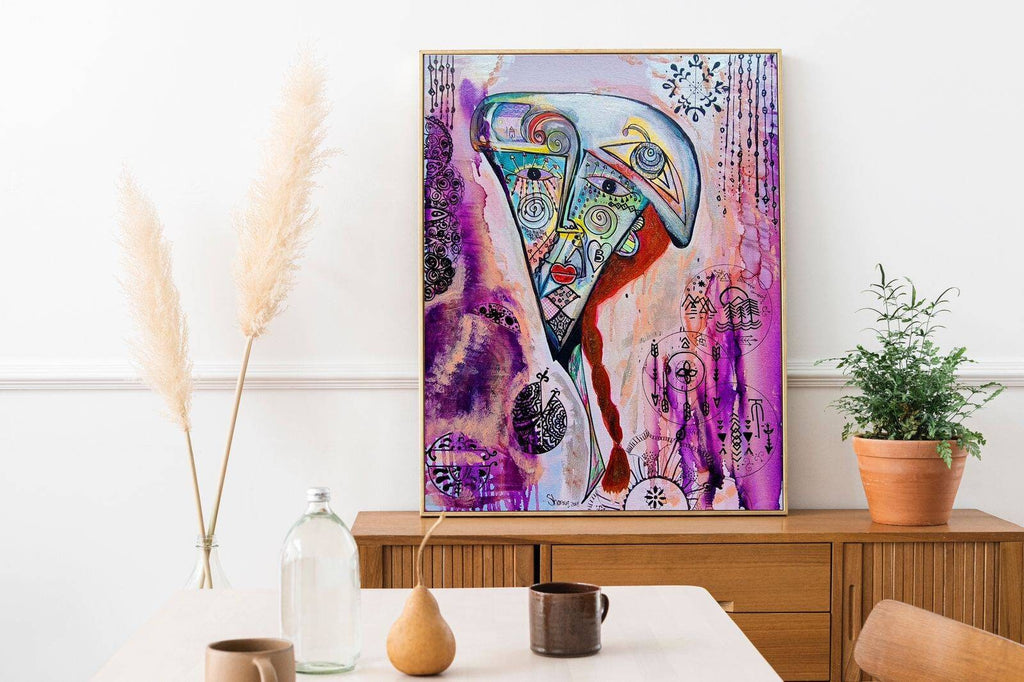 Rosado framed on a white wall above a timber console with pampas grass and a potted plant